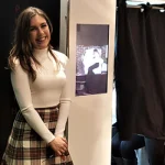 Woman smiling beside a cheap photobooth hire setup with props at an event in Sydney